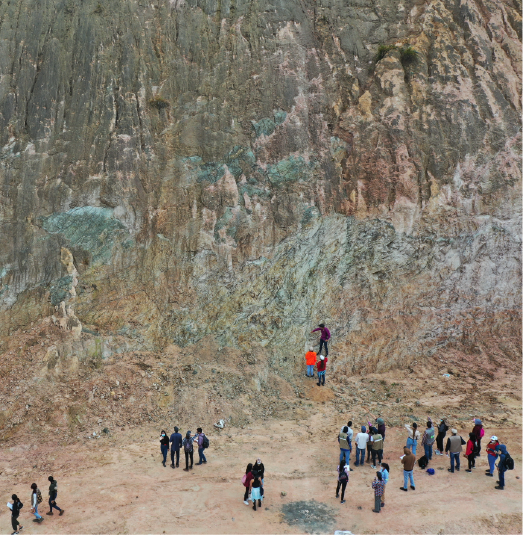 Foto plano general de una montaña y un grupo de estudiantes haciendo trabajo de campo