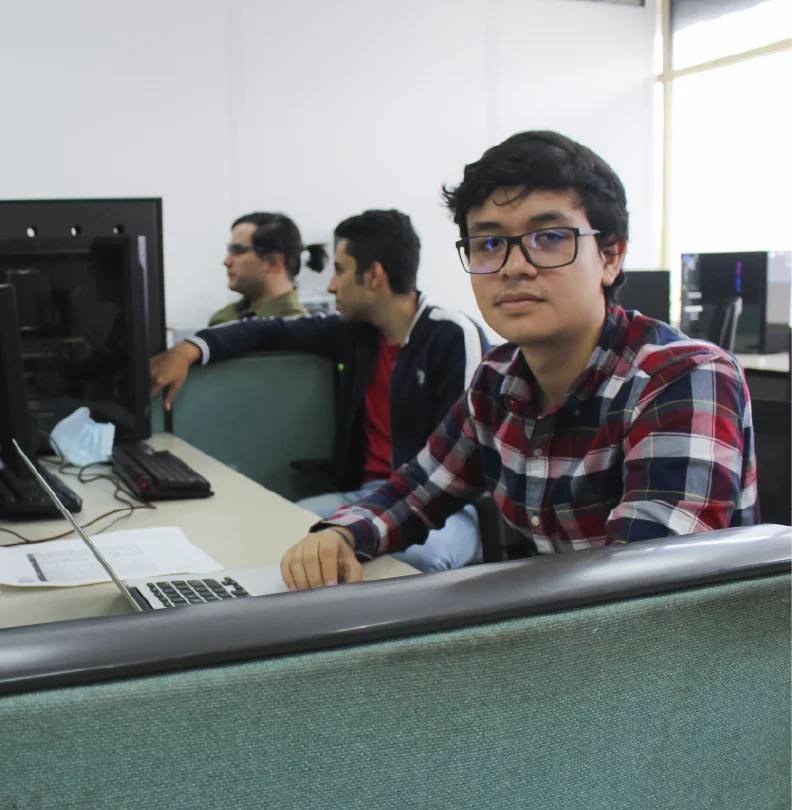 Foto de un estudiante en uno de los salones de los grupos de investigación de la escuela