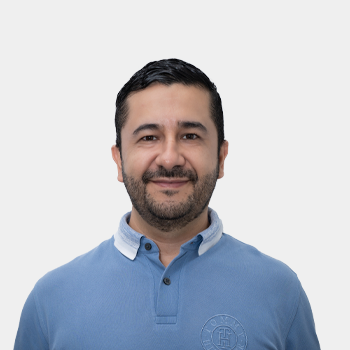 La foto fue tomada en primer plano, fondo blanco y el profesor Andrés Giovanni González Hernández está situado en el centro.