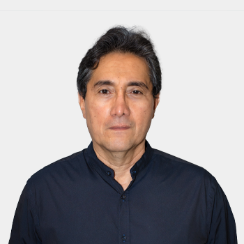 La foto fue tomada en primer plano, fondo blanco y el profesor Luis Eduardo Becerra está situado en el centro.